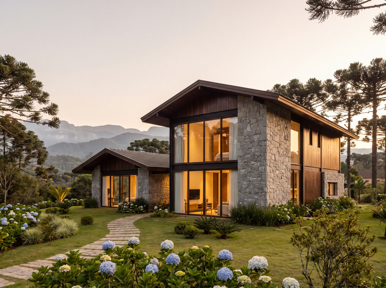 Casa contemporânea de montanha com paredes de pedra, madeira escura e grandes vidros iluminados, entre araucárias e hortênsias, ao entardecer